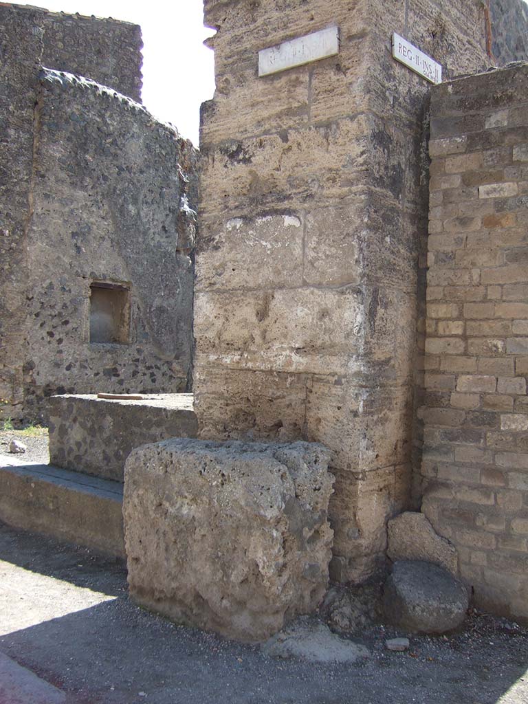 Street altar outside II.2.1 on Via dellAbbondanza, September 2005.
According to Frhlich (from the only source - Spinazzola), in front of the wall stood a white plastered masonry altar.
Above this, the remains of an older painting were visible through a newer lime layer.
This showed five figures, probably the vicomagistri and a tibicen, and a tablet with illegible names.
See Frhlich, T., 1991. Lararien und Fassadenbilder in den Vesuvstdten. Mainz: von Zabern. (F17, p. 312).

