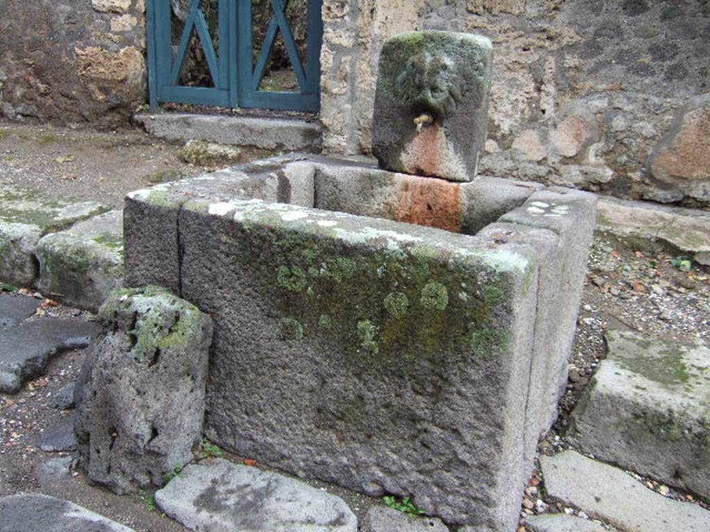 Looking north-east towards fountain outside VI.16.28 on east side of Vicolo dei Vettii. December 2005.