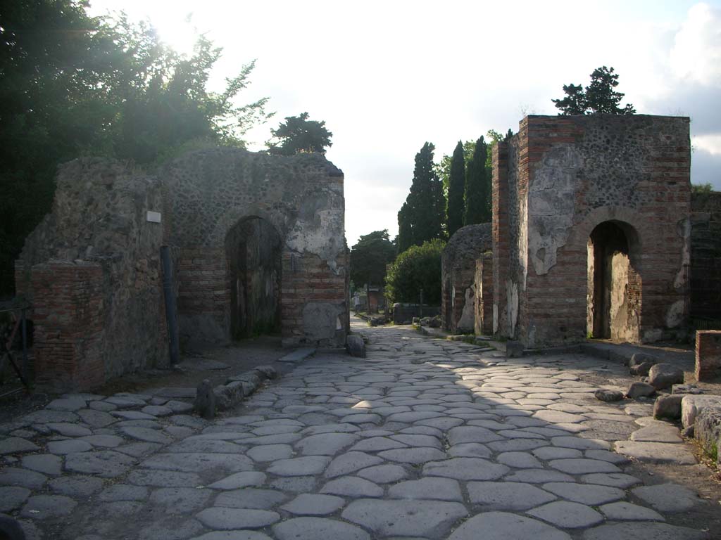 Porta Ercolano or Herculaneum Gate, Pompeii. May 2010. Looking north from Via Consolare through gate. Photo courtesy of Ivo van der Graaff.
According to Van der Graaff –
“As Pompeii developed, the design of its gates had to take into account the increased demographic and economic pressure. 
The narrow passageways present in the earlier gates became points of congestion. …………………….
[At Porta Ercolano], we find two pedestrian entrances framing a central roadway in a monumental design reminiscent of a triumphal arch.
See Van der Graaff, I. (2018). The Fortifications of Pompeii and Ancient Italy. Routledge, (p.103).
