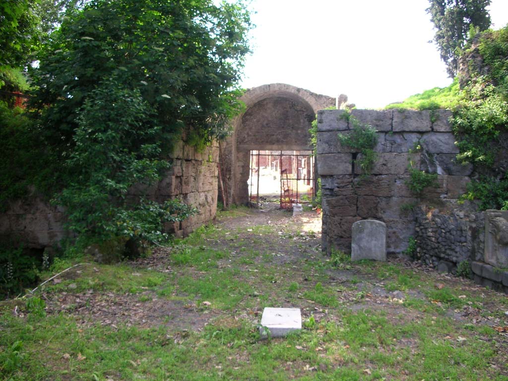 Via Stabiana, Pompeii. May 2010. Looking north through gate from south end, site of bastions. Photo courtesy of Ivo van der Graaff.
According to Van der Graaff –
“The twin bastions at each opening were powerful bulwarks of solid masonry protecting the outer edge of the gates. 
Each is composed of travertine ashlars with distinct grooves either facing the inner corners, such as Porta Vesuvio and Stabia, or looking outward, as at Porta Nola. They once accommodated the doors of a simple two-leafed wooden gate that closed the opening. A further gate also marked the threshold on the city side of the gate (Note 33). The overall layout is simple, designed to allow passage through the deep embankment of the agger. It also carried a defensive advantage to trap any attackers in the court of the gate, allowing troops to pelt the enemy from higher ground.”
See Van der Graaff, I. (2018). The Fortifications of Pompeii and Ancient Italy. Routledge, (p.51).
