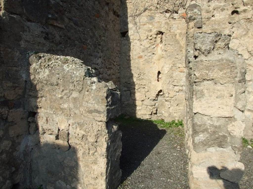 VII.14.2 Pompeii. December 2007. Looking north through doorway to rear room with site of steps to upper floor, and a latrine.
According to Boyce –
a fragmentary painting on the wall of the kitchen appeared to have belonged to a lararium originally painted above it.
Three men (the heads were missing) are busied about a hog: one with staff in his right holds the animal by the ear; 
a second drags on a cord tied about its snout. Below lay the carcass of a slaughtered animal, opened as if for divination from the entrails.
He gave the reference – Helbig 83.
See Boyce G. K., 1937. Corpus of the Lararia of Pompeii. Rome: MAAR 14. (p.71, no.325) 


