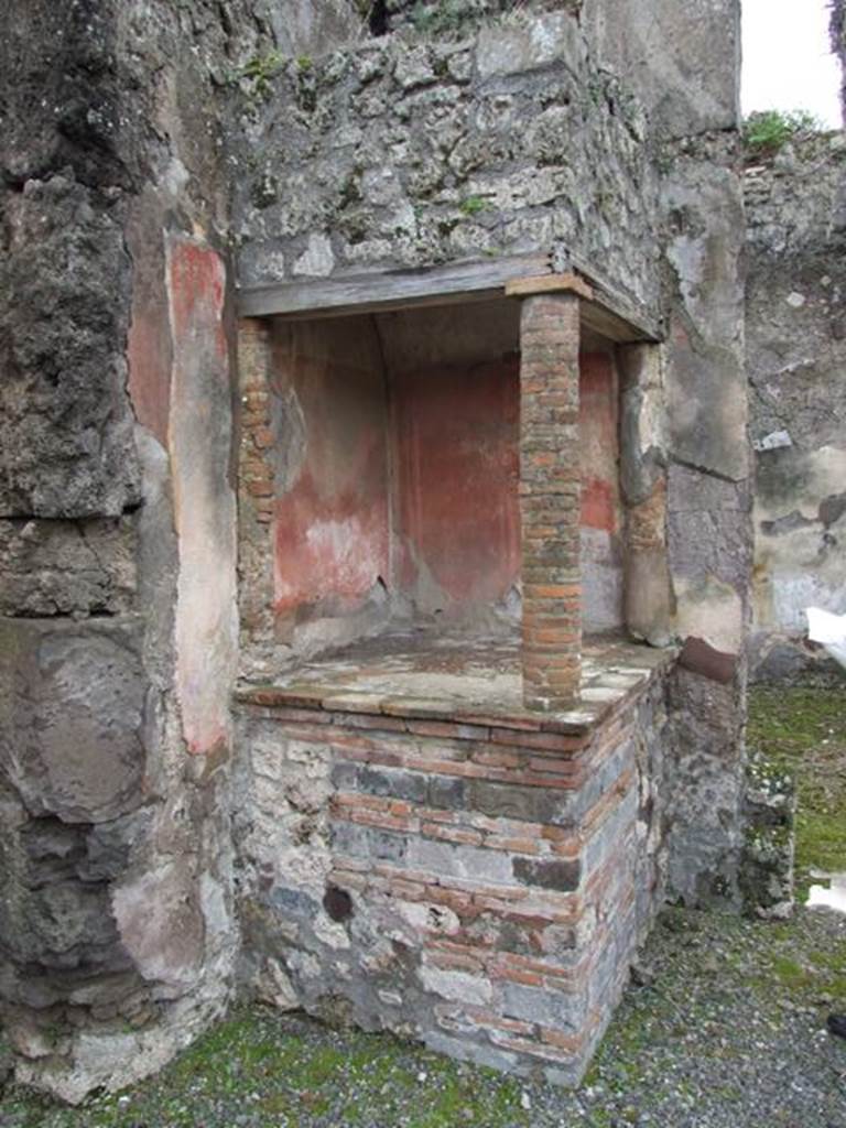 VII.14.5 Pompeii. March 2009. Aedicula lararium in south-west corner of atrium.
According to Boyce- 
above a solid podium (1.20 by 1.10, h.1.02) one column and two half columns applied to the south and west walls (h.1.10) supported a roof.
This formed a kind of niche, the ceiling of which was vaulted.
The inside walls were painted red like those of the room.
See Boyce G. K., 1937. Corpus of the Lararia of Pompeii. Rome: MAAR 14. (p.71, no.326) 
See Giacobello, F., 2008. Larari Pompeiani: Iconografia e culto dei Lari in ambito domestico. Milano: LED Edizioni, (p.245, no.A28)


