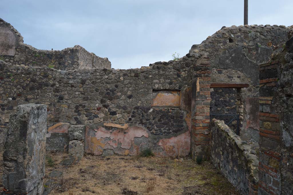 VII.15.12 Pompeii. March 2018. Looking east across room described as “central atrium-like room” or triclinium.
Foto Taylor Lauritsen, ERC Grant 681269 DÉCOR.
According to Boyce – 
in the east wall of the central atrium-like room was a shallow, rectangular niche (h.0.50, w.0.85, d.0.23, h. above floor 1.60) of unusual proportions.
Its walls were coated with yellow stucco and decorated with red stripes; the Bull. Inst. referred to it as “forse un larario”.
See Bullettino dell’Instituto di Corrispondenza Archeologica (DAIR), 1874, 71.
See Boyce G. K., 1937. Corpus of the Lararia of Pompeii. Rome: MAAR 14. (p.72, no.333).
See Giacobello, F., 2008. Larari Pompeiani: Iconografia e culto dei Lari in ambito domestico. Milano: LED Edizioni, (p.282 no.V70)




