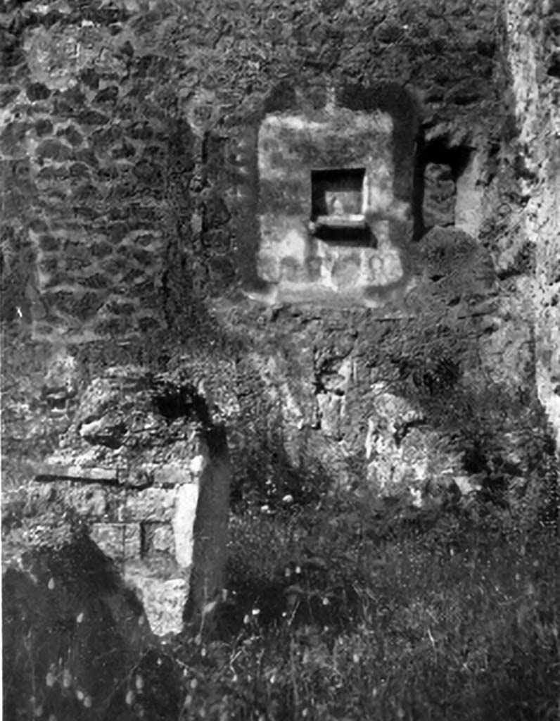 IX.7.21/22 Pompeii. 1937. Lararium in north-west corner of atrium of IX.7.21.
According to Boyce, in the north-west corner of the atrium was the hearth.
Above the hearth in the west wall was a panel of white stucco. In the panel was a square niche.
Its edges were outlined in red against the white background and below it was a cornice.
On the reddish coloured back wall of the niche was painted a white object, which Mau was unable to identify.
He did state that it was not a phallus.
Below the niche was a painted garland of red and green leaves and below it a burning altar with a pine-cone.
On either side of the altar was a yellow serpent.
The serpent on the left had a red crest and beard, the head of the other was damaged.
See Boyce G. K., 1937. Corpus of the Lararia of Pompeii. Rome: MAAR 14.  (p.88, no.441, and Pl.4, 4)
According to Giacobello, the painting is no longer conserved.
See Giacobello, F., 2008. Larari Pompeiani: Iconografia e culto dei Lari in ambito domestico. Milano: LED Edizioni. (p.250)
See Mau in Bullettino dell’Instituto di Corrispondenza Archeologica (DAIR), 1882, (p.195)
