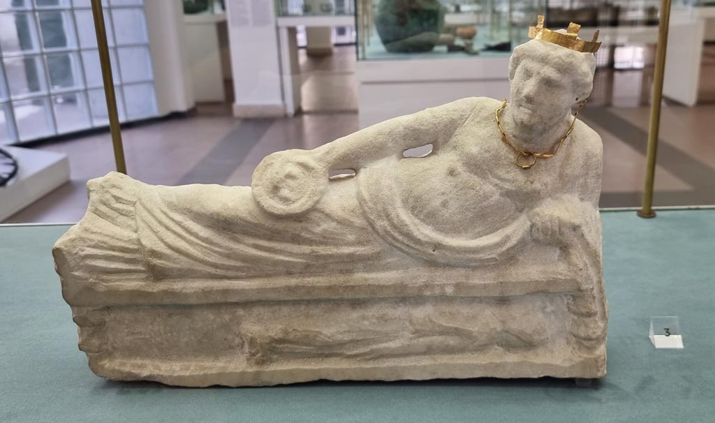 Boscoreale, December 2023. Villa rustica in via Casone Grotta, proprietà Risi di Prisco. Lararium. 
Marble statuette of a female Genius, relaxing on a couch (kline), dressed in chiton and cloak.
The gold ring, necklace and diadem that decorate it were found beside it.
Now in Boscoreale Antiquarium. Photo courtesy of Miriam Colomer. 
See Fergola, L., 1987. Comune di Boscoreale. Via Casone Grotta, proprietà Risi Di Prisco, in Rivista di Studi Pompeiani, I, p. 164.
