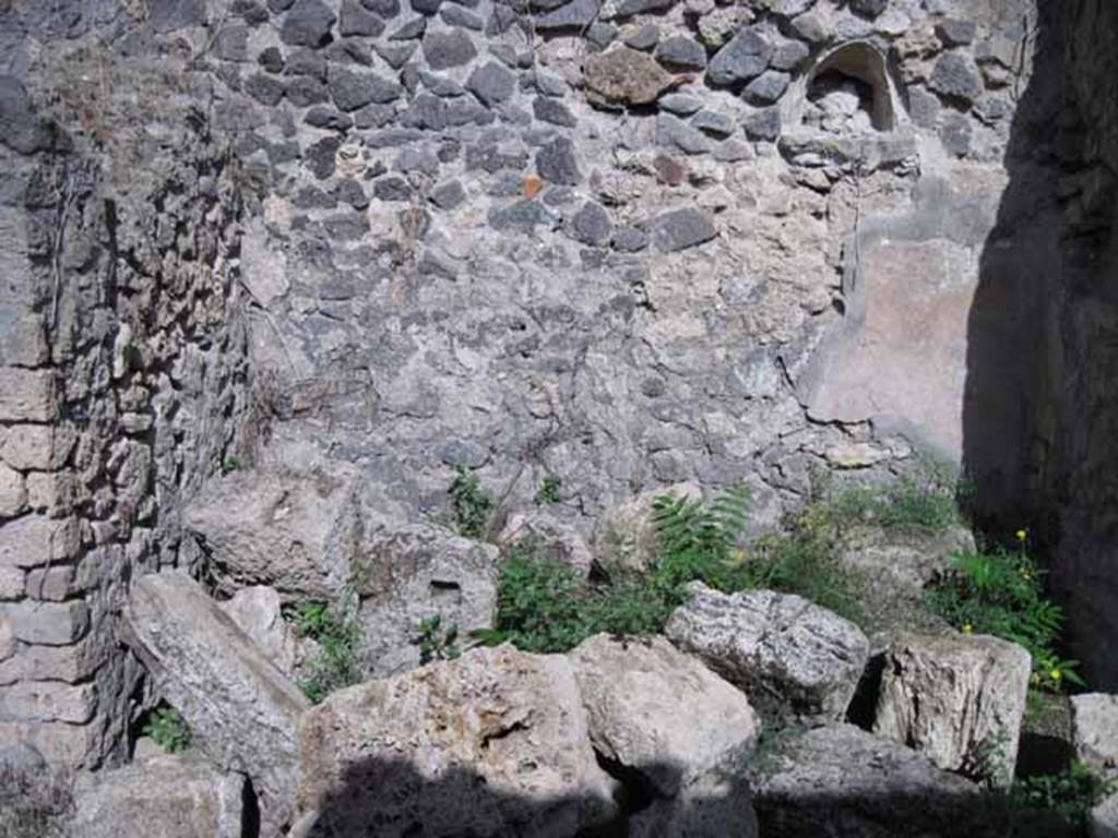 I.2.23 Pompeii. September 2010. East wall of entrance area, with niche.  Photo courtesy of Drew Baker. According to Garcia y Garcia, the dividing wall of a rustic room in this area was destroyed due to the 1943 bombing.
See Garcia y Garcia, L., 2006. Danni di guerra a Pompei. Rome: L’Erma di Bretschneider. (p.37)
