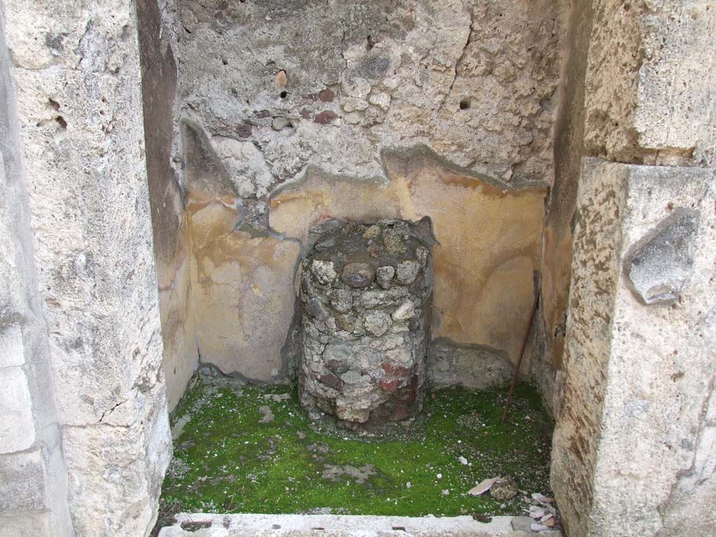 V.1.7 Pompeii. March 2009. Room 5, round altar against south wall in room on east side of entrance corridor.
According to Boyce, this altar is in the form of a half-column, coated with stucco and painted to represent red and yellow variegated marble.
On the yellow background of each side of the altar is painted a serpent coiling among plants.
See Boyce G. K., 1937. Corpus of the Lararia of Pompeii. Rome: MAAR 14. (p. 32, pl.39,4).
According to Giacobello –
“This room was used as a sacrarium (width I.70, depth 0.95) with masonry altar (h.0.90, width 0.40) in the form of a half column, painted in red and yellow in imitation of marble: to the sides of the altar were seen two serpents, no longer conserved.”
See Giacobello, F., 2008. Larari Pompeiani: Iconografia e culto dei Lari in ambito domestico. Milano: LED Edizioni, (p.236, no.A9)



