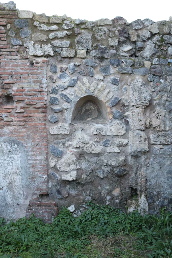 VII.2.12, Pompeii. December 2018. 
Looking towards niche in west wall. Photo courtesy of Aude Durand.
According to Boyce, this arched niche (h.0.34, w.0.44, d.0. 27, h. above floor 1.30),
had walls coated with white stucco and decorated with broad red bands. 
Fiorelli called it la nicchia de’ Penati.
See Boyce G. K., 1937. Corpus of the Lararia of Pompeii. Rome: MAAR 14. (p.61, 248) 
See Pappalardo, U., 2001. La Descrizione di Pompei per Giuseppe Fiorelli (1875). Napoli: Massa Editore. (p.81)

