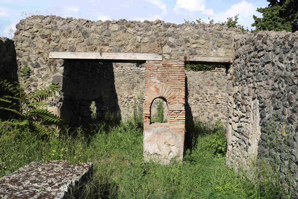 I.1.2 Pompeii. September 2018. 
Looking east, at front, remains of podium in selling room. At the rear are entrances to two rear rooms. Photo courtesy of Aude Durand.

