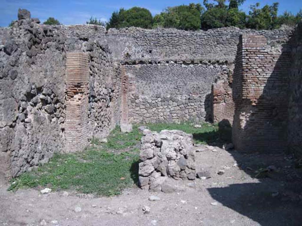 I.1.4 Pompeii. September 2010. Looking east from entrance across the shop-room to a rear room. The remains of a large masonry bench are in the centre of the shop-room. Photo courtesy of Drew Baker.
