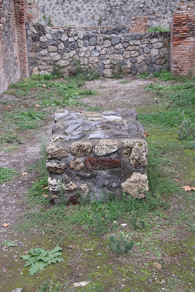 I.1.4 Pompeii. October 2024. 
Looking east towards large masonry bench in the centre of the shop-room. Photo courtesy of Klaus Heese.
