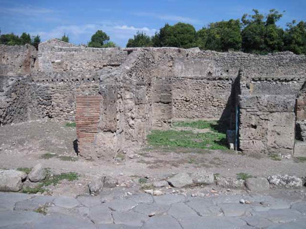 I.1.5 Pompeii. September 2010. Entrance on Via Stabiana, looking east.
Photo courtesy of Drew Baker.
According to Warscher, quoting Mau in Bull. Inst. 1875, p.29, 
I.1.4/5 - Mentre le localit servivano per i carri e per il bestiame da tiro e come camere da letto, lungo la strada, a sinistra dello ingresso, stanno altre localit (nos.4 and 5) che evidentemente servivano da caupona per i carrettieri e per altri avventori.  Vi sono due locali con larga apertura sulla strada, a guisa di botteghe, congiunte mediante una porta, e in ciascuno di cui d unaltra stanza con apertura larga anchessa, queste ultime non congiunte fra di loro, mentre quella meridionale ha una porta su quel locale per cui si passa nel cortile. In mezzo al locale anteriore no.4 si trova una tavola di materiale piuttosto piccola, sulla quale si metteva senza dubbio una tavola pi grande di legno per mangiare.  Avanti alla porta del locale no.5 e lungo il muro laterale della casa adiacente, che sporge un poco nella strada, vi  una panca di materiale, quale trovammo avanti alla caupona (also see I.1.6/9)
See Warscher T., 1936. Codex Topographicus Pompeianus: Regio I.1, I.5. (no.13), Rome: DAIR, whose copyright it remains.
See Warscher T., 1936. Codex Topographicus Pompeianus: Regio I.1, I.5. (no.13), Rome: DAIR, whose copyright it remains.
(translation: While the locality served for wagons and animals and as sleeping accommodation, along the road, to the left of the entrance, were other places (nos. 4 and 5) that evidently served as caupona for the carters and other patrons.  There were two rooms with a wide opening onto the road in the guise of shops, joined through a door, and in each of which had another different room also with a wide opening, these last did not join each other, while the southern one had a door which passed into the courtyard. In the middle of the front room of no. 4 was a table of material, rather small, on which one would undoubtedly have placed a larger wooden table for eating. Before the door of the premises no. 5 and along the side wall of the adjacent house, which protruded a little onto the street, there was a bench of material, which was found before the caupona.)
