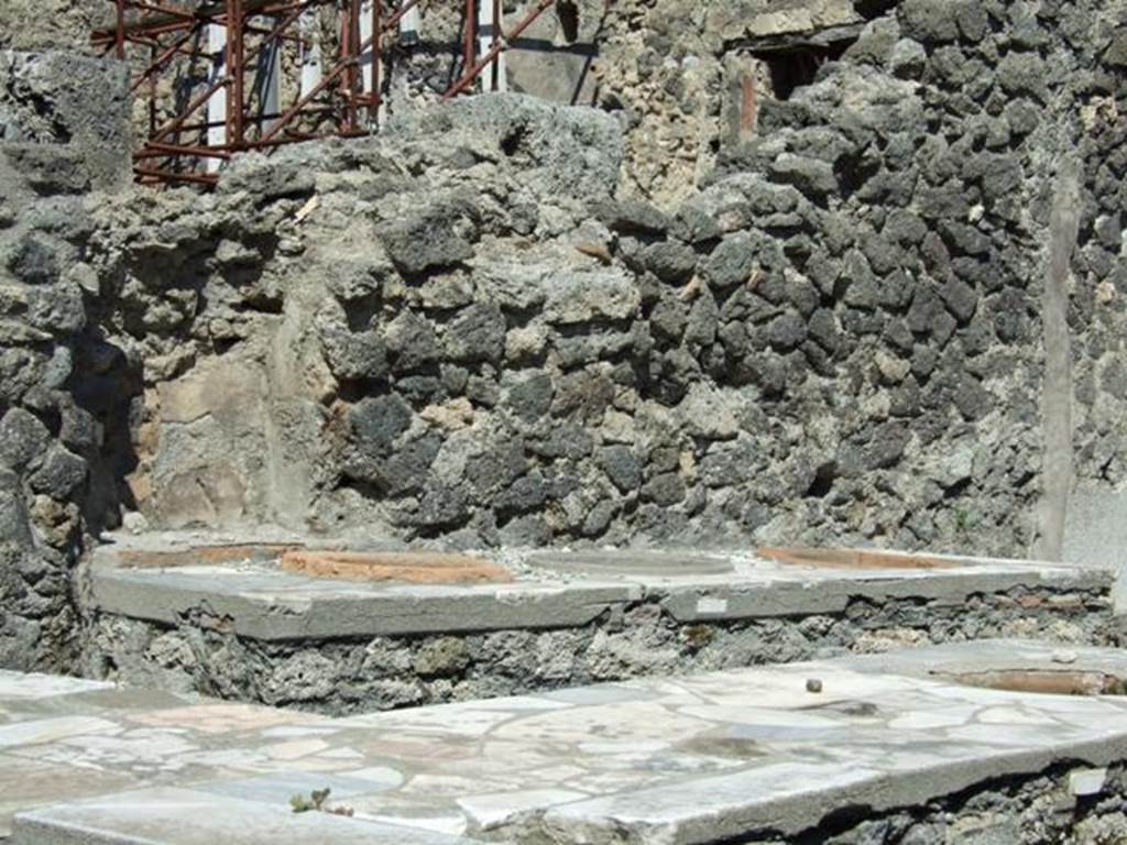 I.2.8 Pompeii. March 2009. North wall with niche behind additional counter with three urns, and L-shaped serving counter in the front.
