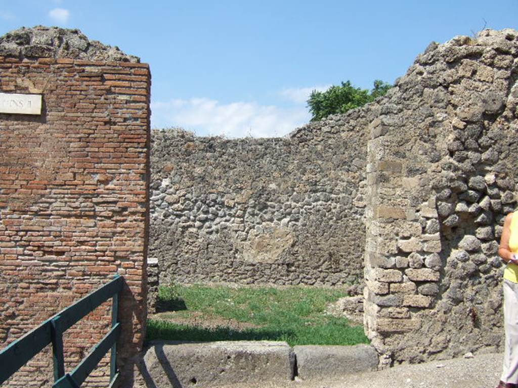 I.2.32 Pompeii. September 2005.  Entrance.
According to Fiorelli there were various painted graffiti on the plaster on the outside wall at the side of the doorway. Three of them were 
1) poLYBIVM      2) POPIDIVM. RVFVM.AED             3) POPIDIUM Rufum.         
                              .....ROGANT
See Pappalardo, U., 2001. La Descrizione di Pompei per Giuseppe Fiorelli (1875). Napoli: Massa Editore. (p.33)

