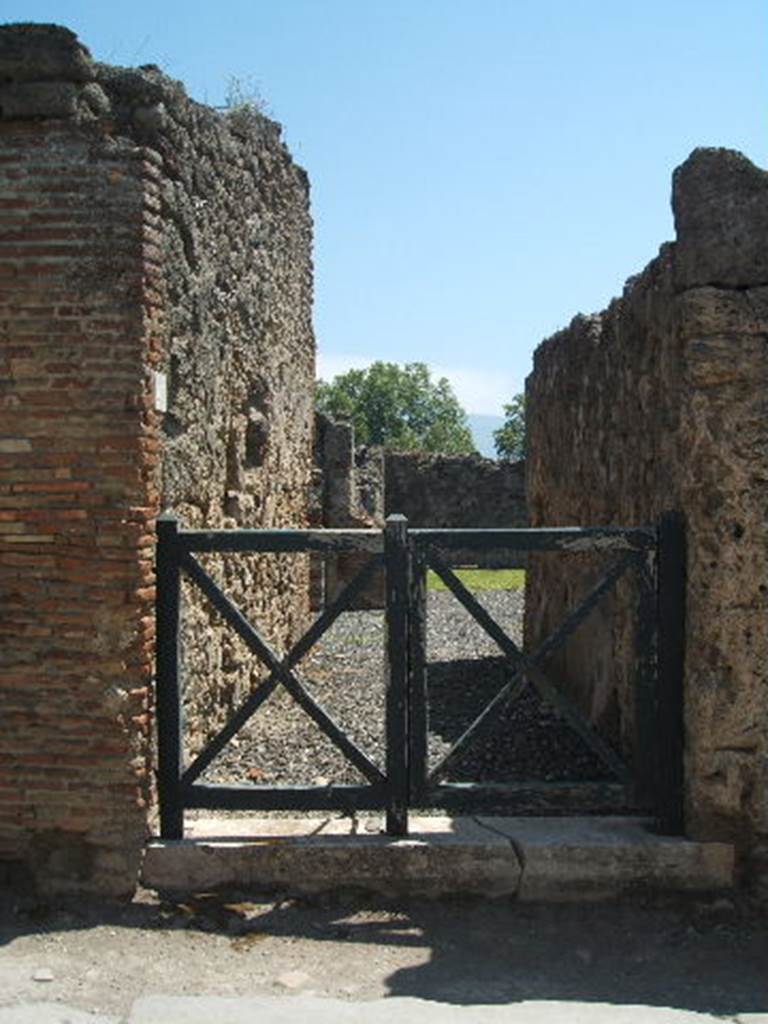 I.3.20 Pompeii. May 2005. Entrance doorway. According to Warscher, “Il protiro conduce in un atrio privo dell’impluvio. A destra una ampia cella con tre poggiuoli di fabbrica, per sostegno di un pancone di tavola, e di fronte il tablino. Nel viridario sono infissi due dolia.”
(Translation: The entrance corridor into an atrium without an impluvium. 
On the right a large room with three masonry blocks, for the support of a board for the table, and the tablinum opposite.  In the garden area were two dolia fixtures. "
