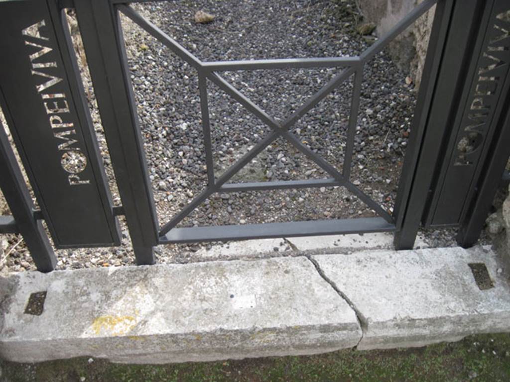 I.3.20 Pompeii. September 2010. 
Looking south to detail of marble entrance threshold block, showing doorpost slots. 
Photo courtesy of Drew Baker.
