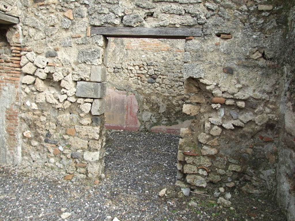 I.3.24 Pompeii. December 2006. Doorway to cubiculum on east side of peristyle.
According to Fiorelli, the wall painting of a lion, hind, dog and hare found in the corner of the walkway, was found next to this doorway. See Pappalardo, U., 2001. La Descrizione di Pompei per Giuseppe Fiorelli (1875). Napoli: Massa Editore, (p.40)
According to Bull. Inst. –  “In un altro angolo del peristilio è dipinto, nella maniera grossolana delle pitture topiarie, un leone che dilania una cerva e più sotto un cane che addenta una lepre”. (translation: "Found painted in a coarse manner in another corner of the peristyle was a lion tearing apart a hind and beneath a dog biting a hare".) See BdI, 1869, p.239-240.
