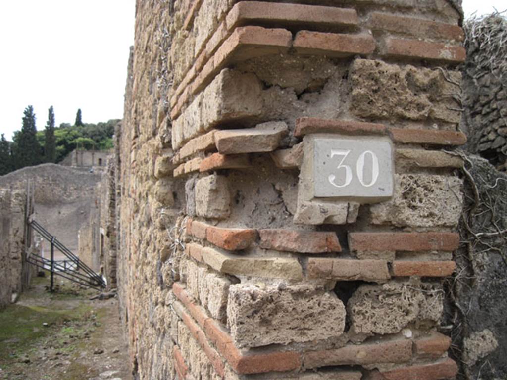 I.3.30 Pompeii. September 2010. ID number plate on west side of entrance doorway.
Photo courtesy of Drew Baker. Looking west along unnamed vicolo towards Via Stabiana. Fiorelli called this vicolo via secunda.  See Pappalardo, U., 2001. La Descrizione di Pompei per Giuseppe Fiorelli (1875). Napoli: Massa Editore. (p.41)
