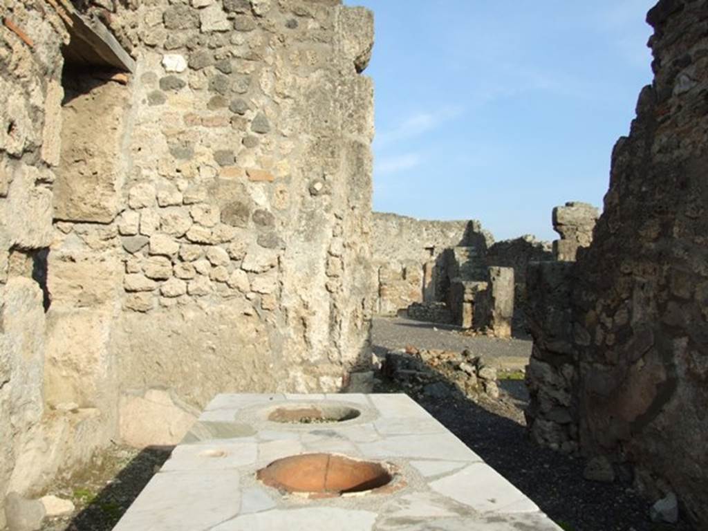 I.4.3 Pompeii. December 2007.   Marble counter . In the east wall at the rear, the doorway leads into the atrium of I.4.2.

