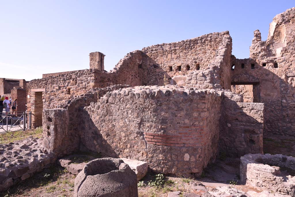 I.4.12 Pompeii. October 2019. 
Room b, bakery room, north-west corner, with rear of oven in I.4.13, in centre, and doorway into room h, on right.
Foto Tobias Busen, ERC Grant 681269 DCOR.
