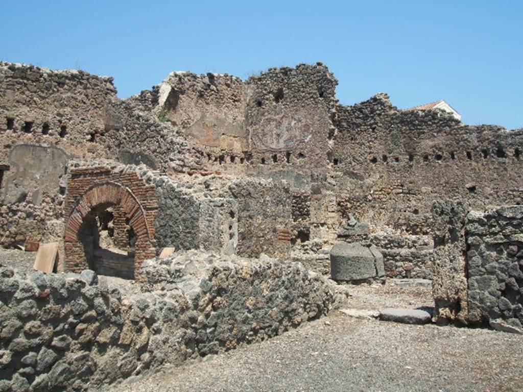 I.4.12 Pompeii. May 2005. Looking through doorway towards rear room of bakery with millstones.