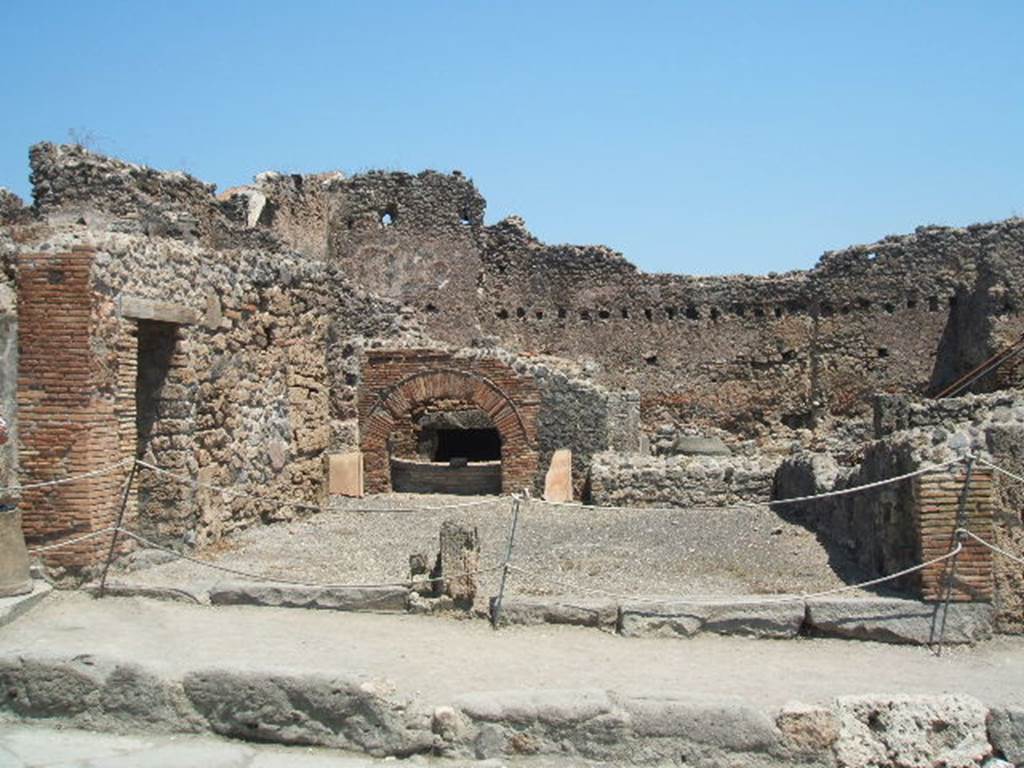 I.4.13 Pompeii. May 2005. Looking east across shop and bakery. The door on the left links to I.4.14.
