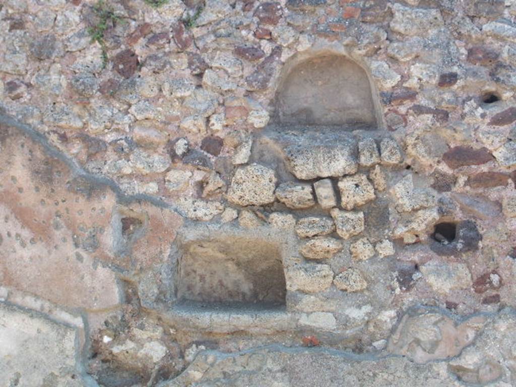 I.4.16 Pompeii. May 2005.  Two niches on south wall. According to Boyce, either or both of these could have been lararia.  The upper niche was arched and had its walls coated with red stucco. The lower rectangular niche had a back wall which curved from back to front. Its walls were coated with white stucco decorated with painted red dots, to represent flowers.
See Boyce G. K., 1937. Corpus of the Lararia of Pompeii. Rome: MAAR 14. (p.25) 
