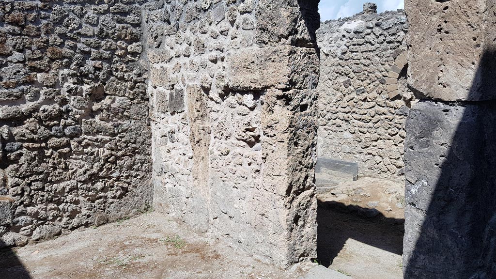 I.5.2 Pompeii. August 2023. Looking north from industrial area towards doorway on west side. Photo courtesy of Maribel Velasco.