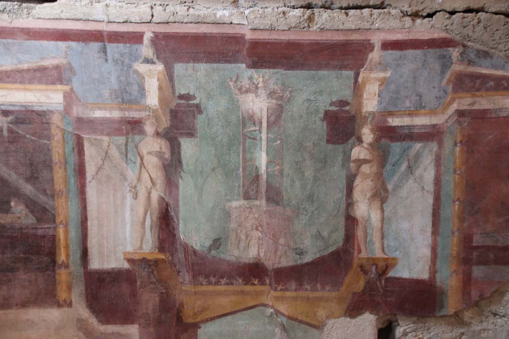 I.6.2 Pompeii. May 2006. Frigidarium, north wall. Detail of upper centre. According to Peters, this shows a tripod on a base with relief, against a background of trees. He said the relationship between the tripod and Apollo was a well-known one. See Peters, W.J.T. (1963): Landscape in Romano-Campanian Mural Paintings.The Netherland, Van Gorcum & Comp. (p.24 and fig.13).