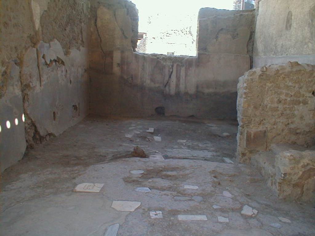 I.6.3 Pompeii. May 2005. Looking south across workshop, with steps to upper floor on the right. The high zoccolo of Opus signinum with panels separated by black bands and edged by thin red lines formed the simple decoration of this workshop, and followed the line of the stairs leading above.  The decoration of the Opus signinum floor had inserted polychrome marble tiles. In the south wall of the rear room was a window, which took its light from the atrium of the neighbouring house at I.6.2.


