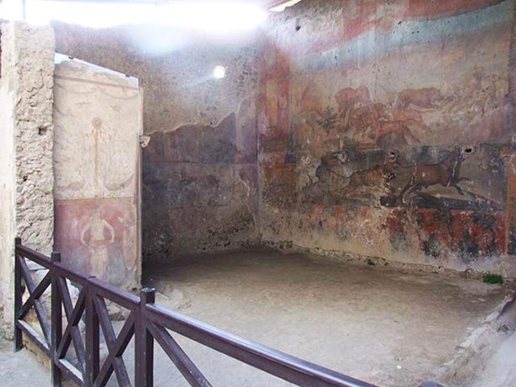 I.6.15 Pompeii. June 2019. Room 9, small garden. 
Wall on west side with painting with birds, plants and a medallion above a figure holding a basin or bowl.
Photo courtesy of Buzz Ferebee.
