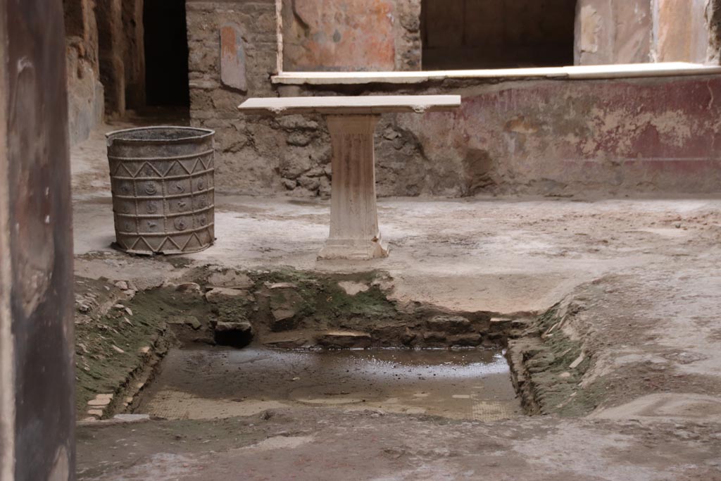 I.7.3 Pompeii. May 2024. Looking towards lead bucket and table on south side of impluvium. Photo courtesy of Klaus Heese.