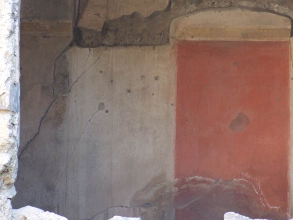 I.7.5 Pompeii. December 2007. Painted wall plaster from south wall of closed tablinum.
The room was decorated with a black zoccolo or dado. The middle zone of the south wall had a red central aedicula with a hanging garland and the side panels were black separated by thin painted pilasters, yellow frieze. The upper zone of the wall was also painted black.
