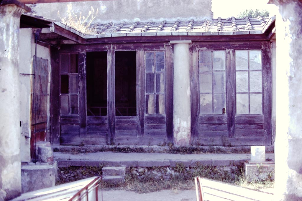 I.7.11 Pompeii, 1978. 
Looking towards north portico from garden area. Photo by Stanley A. Jashemski.   
Source: The Wilhelmina and Stanley A. Jashemski archive in the University of Maryland Library, Special Collections (See collection page) and made available under the Creative Commons Attribution-Non-Commercial License v.4. See Licence and use details.
J78f0359
According to Jashemski, Maiuri said the space between the columns and the west pillar of the portico were closed by glass set in a wooden frame.
This would have kept the rain and sun from the triclinium, tablinum and exedra.
Maiuri did not mention finding any glass and some scholars think that wooden shutters were used.
See Jashemski, W. F., 1993. The Gardens of Pompeii, Volume II: Appendices. New York: Caratzas, (p.38).
