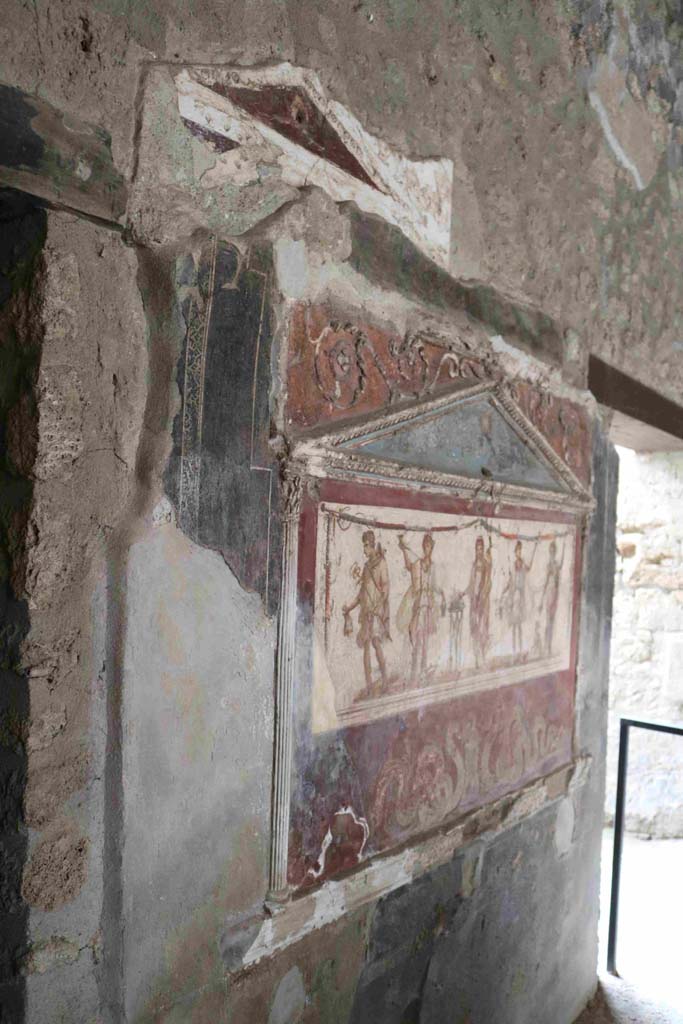 I.8.8 Pompeii. December 2018.Lararium on south wall. Photo courtesy of Aude Durand.
The central figure is the Genius of the household next to a three-legged altar.  
On either side of him are the two Lares. On the left side is Mercury with his money bag.  
On the right side is Bacchus with his panther drinking from a cup held in his right hand.  
Underneath are two serpents approaching a round altar.  
See Fröhlich, T., 1991, Lararien und Fassadenbilder in den Vesuvstädten.  Mainz: von Zabern. (L8: p.252).
