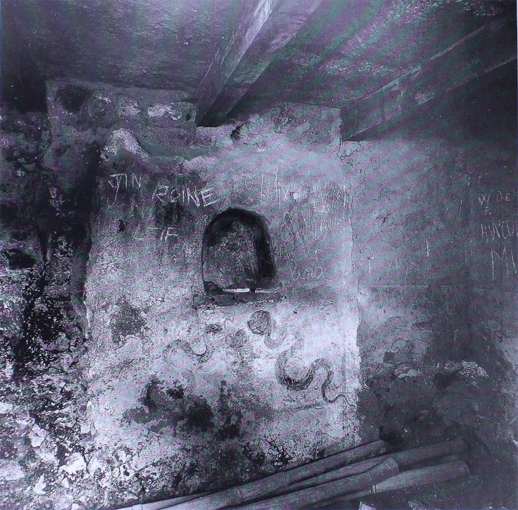I.8.18 Pompeii. Old photo of lararium on the south wall in the kitchen.
According to Giacobello, this is the lararium in the kitchen of I.8.18.
She shows a contemporary photograph to confirm this.
According to Frhlich, in a 1941 archive photograph it was said to be in the atrium of I.8.17 Casa dei Quattro Stili.
He considered the niche remaining in I.8.17 did not have enough room on its left side to fit in the left Lar and serpent.
He attributed it to an unspecified house in insula I.8, because from 1937 to 1941 this was the only place excavations took place.
See Giacobello, F., 2008. Larari Pompeiani: Iconografia e culto dei Lari in ambito domestico. Milano: LED Edizioni. (p.142).
See Frhlich, T., 1991. Lararien und Fassadenbilder in den Vesuvstdten. Mainz: von Zabern. (L10, p.254, Taf. 25,3).
