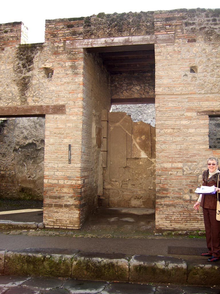 I.9.1 Pompeii. December 2005. Entrance.
According to Boyce, on both walls of the vestibule figures of six divinities had been painted.
The last refashioning of the faade destroyed two of the figures.
On the east wall were Mercury and Hercules, and a missing figure which Della Corte thought was Bacchus.
On the west wall were Minerva and Juno, and traces of a third figure which Della Corte suggested was Venus Pompeiana.
See Notizie degli Scavi di Antichit, 1913, p. 34.
See Della Corte, M., 1965. Case ed Abitanti di Pompei. Napoli: Fausto Fiorentino. (p.339).
See Boyce G. K., 1937. Corpus of the Lararia of Pompeii. Rome: MAAR 14. (p.110, no.3).
