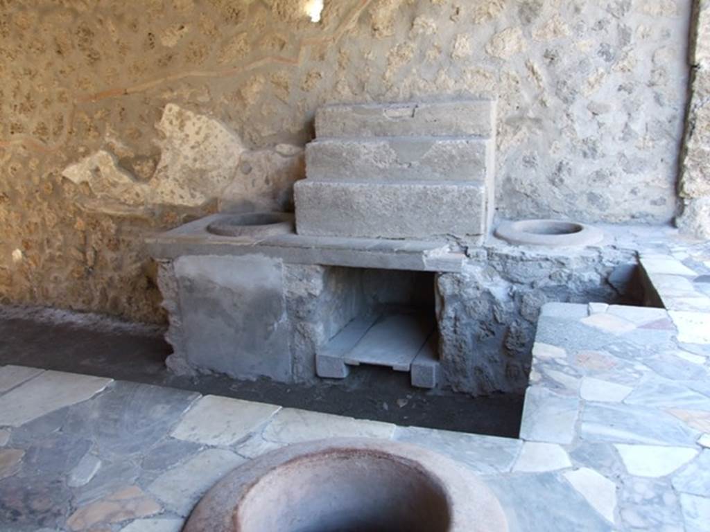 I.9.4 Pompeii.  March 2009.  Display shelving and two urns on west side of counter.