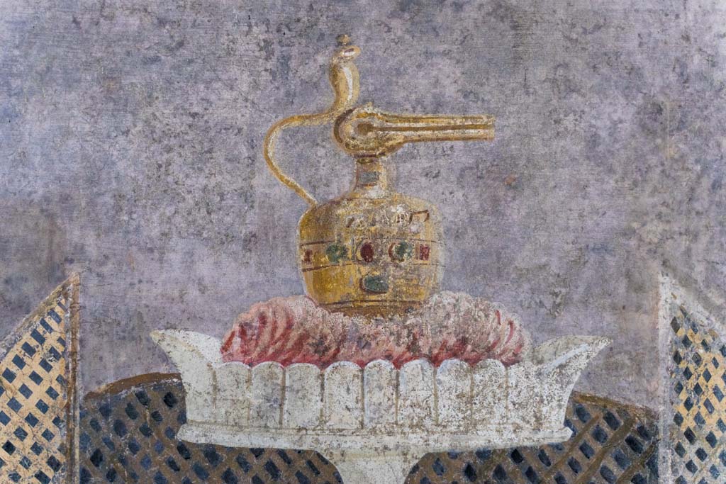 I.9.5 Pompeii. April 2022. Room 11, detail of painted table with Isis jug or jar on east wall. Photo courtesy of Johannes Eber.