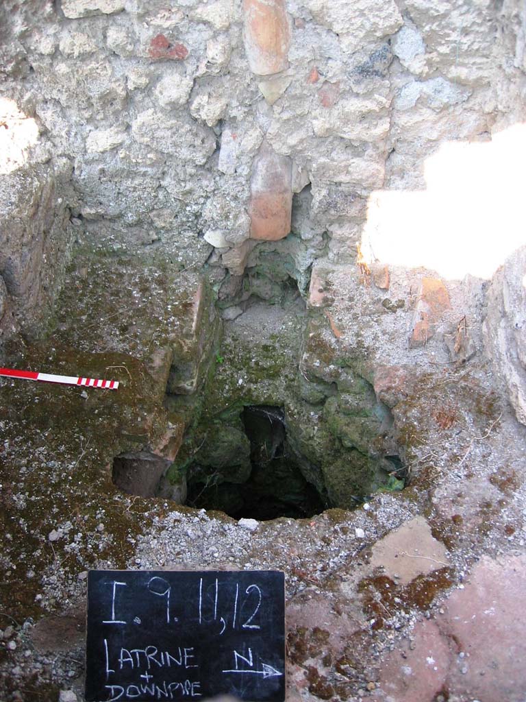 I.9.11 Pompeii. July 2006. 
Looking west towards latrine and downpipe in west wall. Photo courtesy of Barry Hobson.
