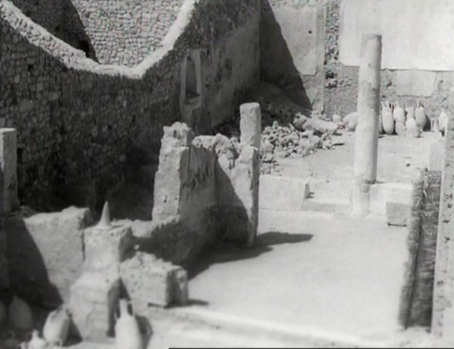I.9.12 Pompeii. Photo taken in 1952. Looking west across the impluvium at amphorae found in atrium.