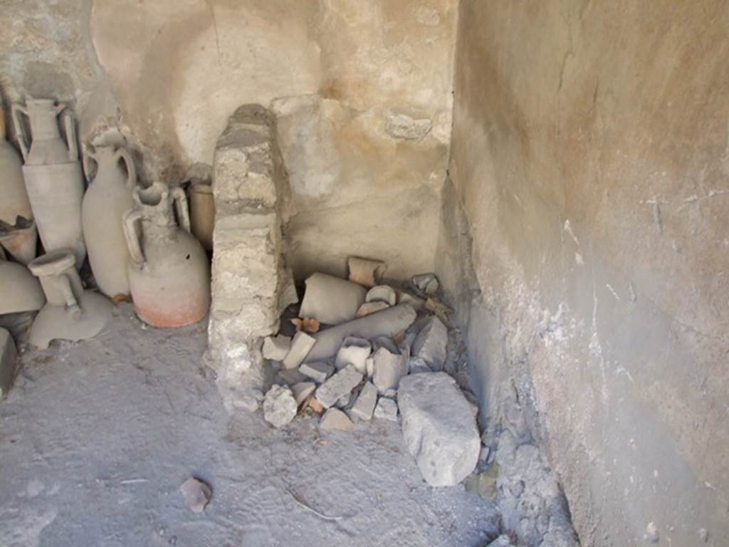 I.10.7 Pompeii. March 2009. Room 1, latrine. According to Hobson, Ling wrote in 1997, that this latrine was screened on the south by a low masonry wall. On the east side, apparently, screened by a timber or timber-framed partition, the evidence for which was an iron-lined posthole in the floor. In fact, it is likely that this was a swivel post for a wooden door and the jamb against the wall. Due to the lack of preservation of wood in Pompeii, no doors have been found. See Hobson, B., 2009. Latrinae et foricae: Toilets in the Roman World. London; Duckworth. (p.82)
