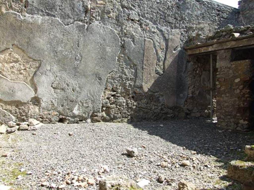 I.10.8 Pompeii. March 2009. Room 5, east wall of the yard, with doorway to room 7 in south-east corner.  