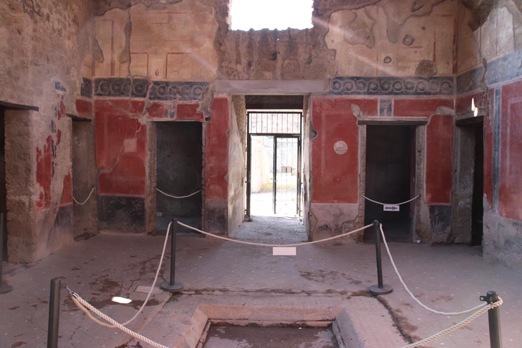 I.10.11 Pompeii. October 2022. 
Room 2, looking west across impluvium in atrium towards entrance corridor, in centre. Photo courtesy of Klaus Heese. 
