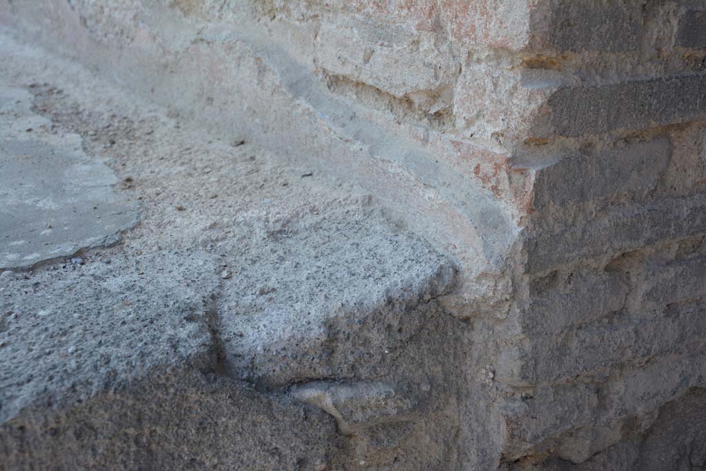 I.10.18 Pompeii. April 2017. Detail of remaining painted plaster at rear of bench seating on south side of entrance doorway. 
Photo courtesy Adrian Hielscher.

