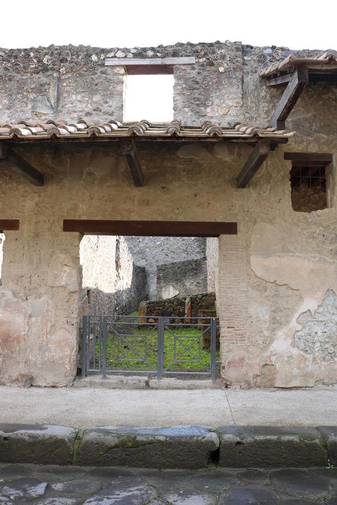 I.11.2 Pompeii. December 2018. Looking south to entrance doorway.
One of the windows in the upper floor can be seen above the doorway. Photo courtesy of Aude Durand
