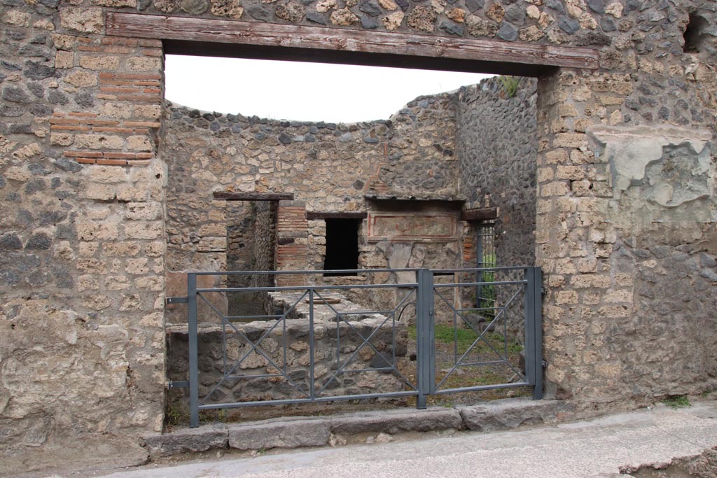 I.11.11 Pompeii. May 2024. Looking north-east to entrance doorway, with bar-counter. Photo courtesy of Klaus Heese.