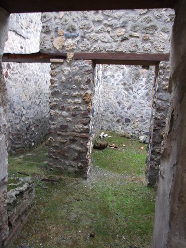 I.11.16 Pompeii. December 2007.  Room 10, the kitchen, looking south towards doorways of rooms 11 and 12. According to Packer, room 12 may have been a dormitory for slaves.
There were no traces of stucco on the walls of rooms 10 or 11, but in room 12 the stucco was plain white. The room on the upper floor above room 12 may have been painted yellow. 
