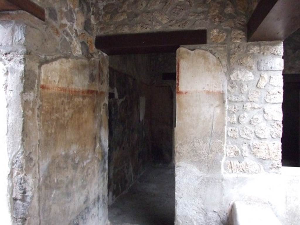 I.11.16 Pompeii. December 2007. Corridor 9, looking west along passageway towards room 3, the bar-room/covered atrium.
According to Packer, the walls of this corridor were painted, with a black dado varying in height, and red borders partitioning the white main zone into panels.
