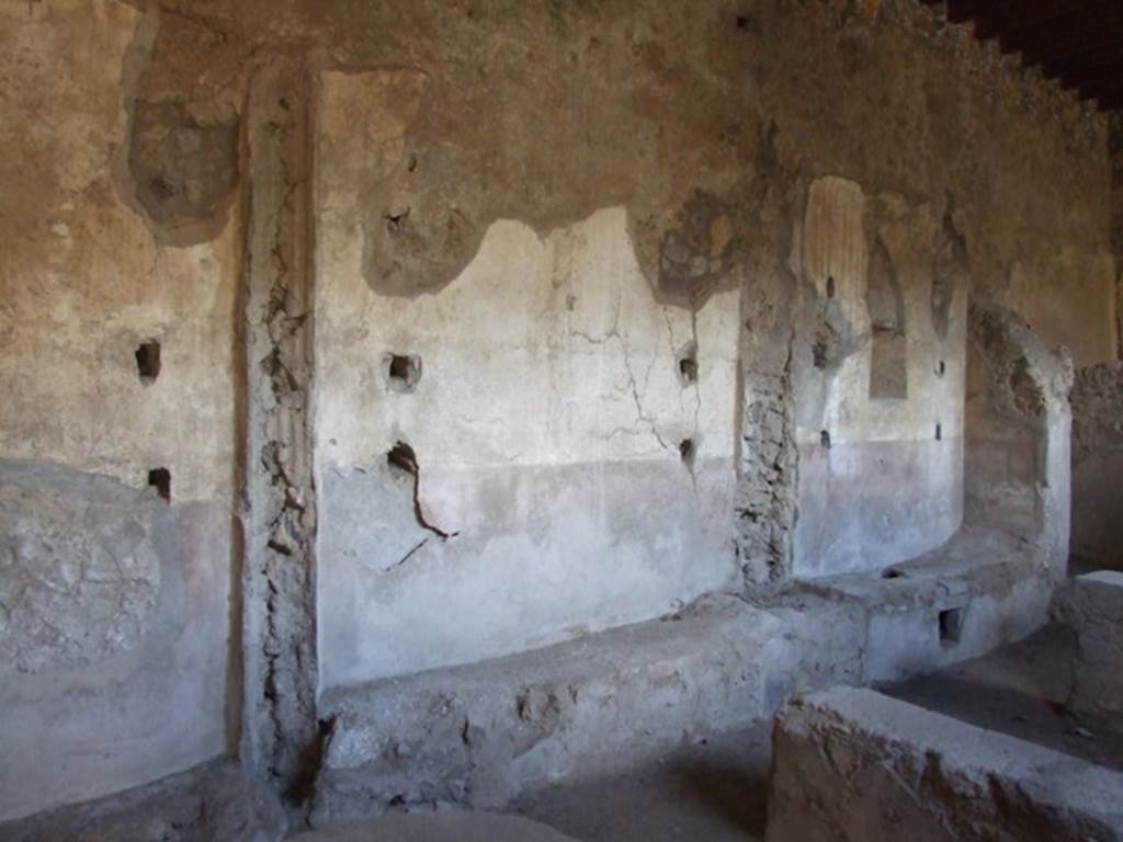 I.12.2 and I.12.1 Pompeii.  March 2009  Room 13. East wall, with remains of holes for shelving supports.